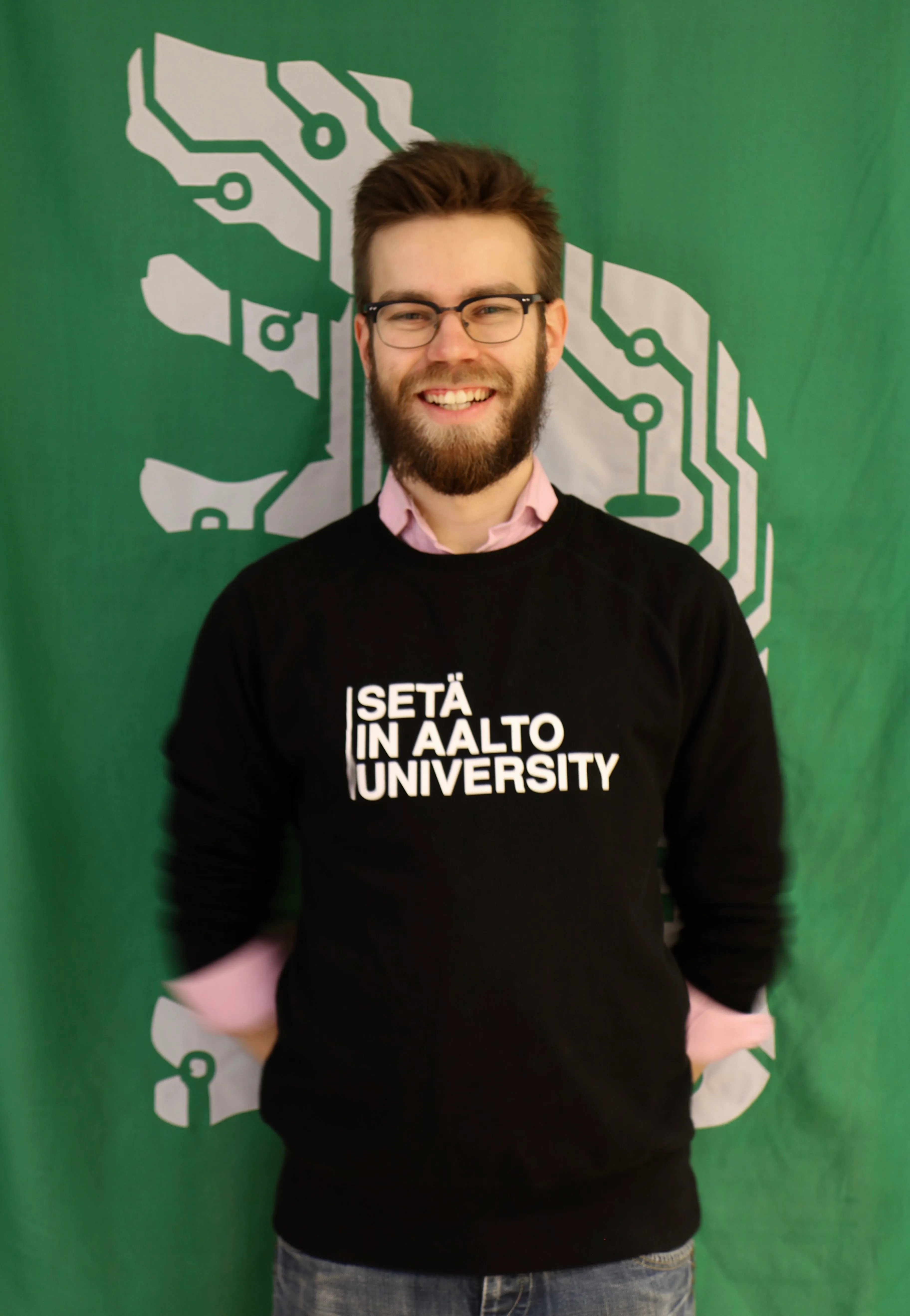 Me, Joonas, smiling at a photoshoot with the flag of the guild of Inkubio on the background